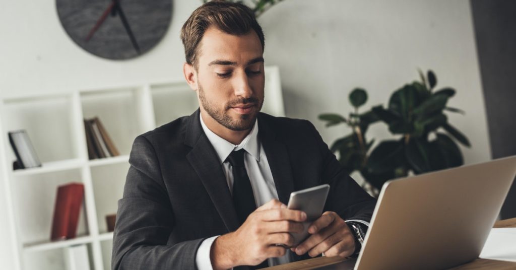 Man deciding whether to call or email to cancel an interview