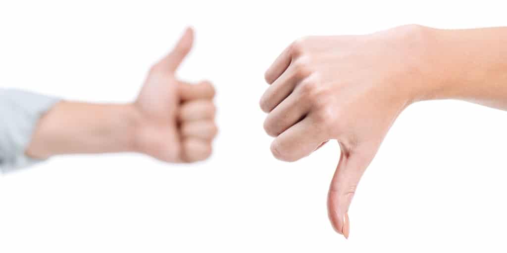 Two hands, one giving the thumbs up, the other thumbs down