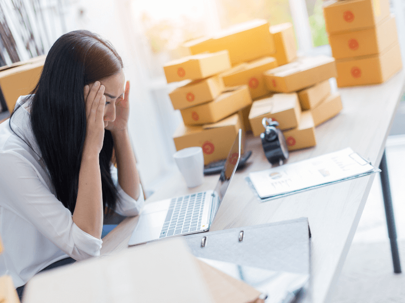 Lady with her head in her hands at her desk