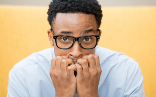 Employee suffering from return to work anxiety, slouched and biting his nails