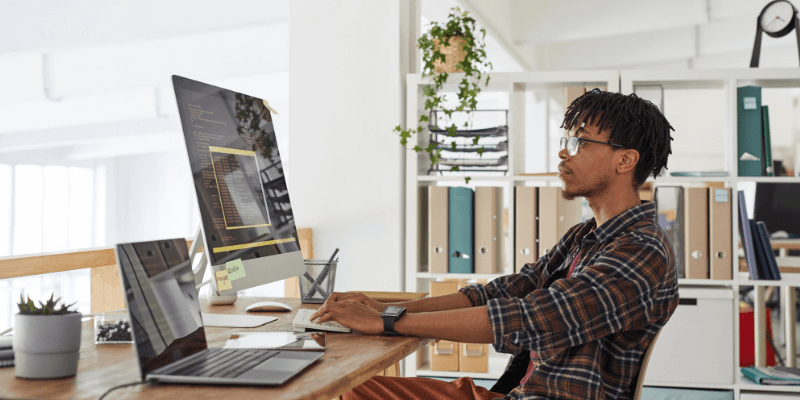 Junior Front End Developer working on his latest project at a computer