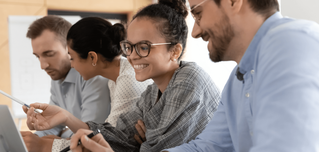 Four happy employees working at their desk