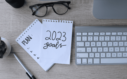 Computer keyboard and notepad with note about 2023 goals. This candidate is considering how job hunting will be different in 2023.