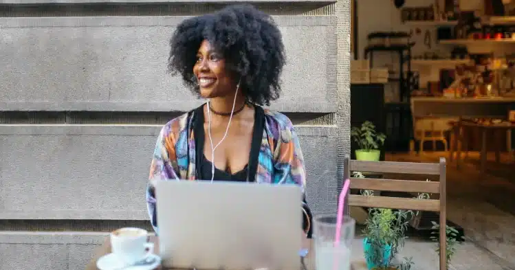 A black woman living and working abroad thanks to a digital nomad visa works from a local cafe