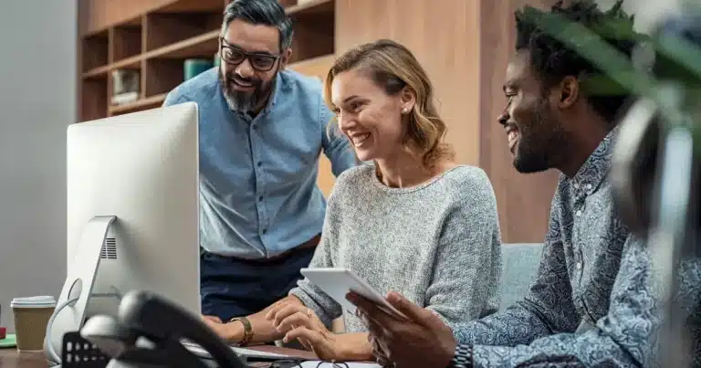 A woman and two men look at the website of Adria Solutions, looking for a trusted IT Recruitment Agency in Preston, Lancashire, to fill a business-critical position as soon as possible.
