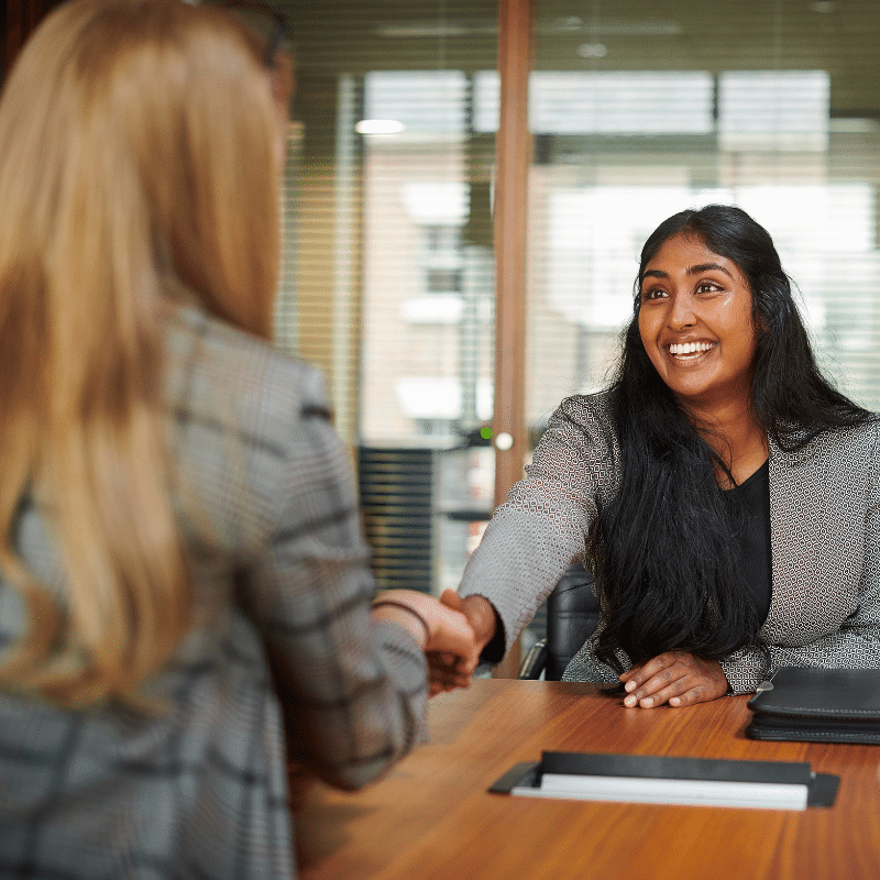 Smiling businesswoman shaking hands at a job interview