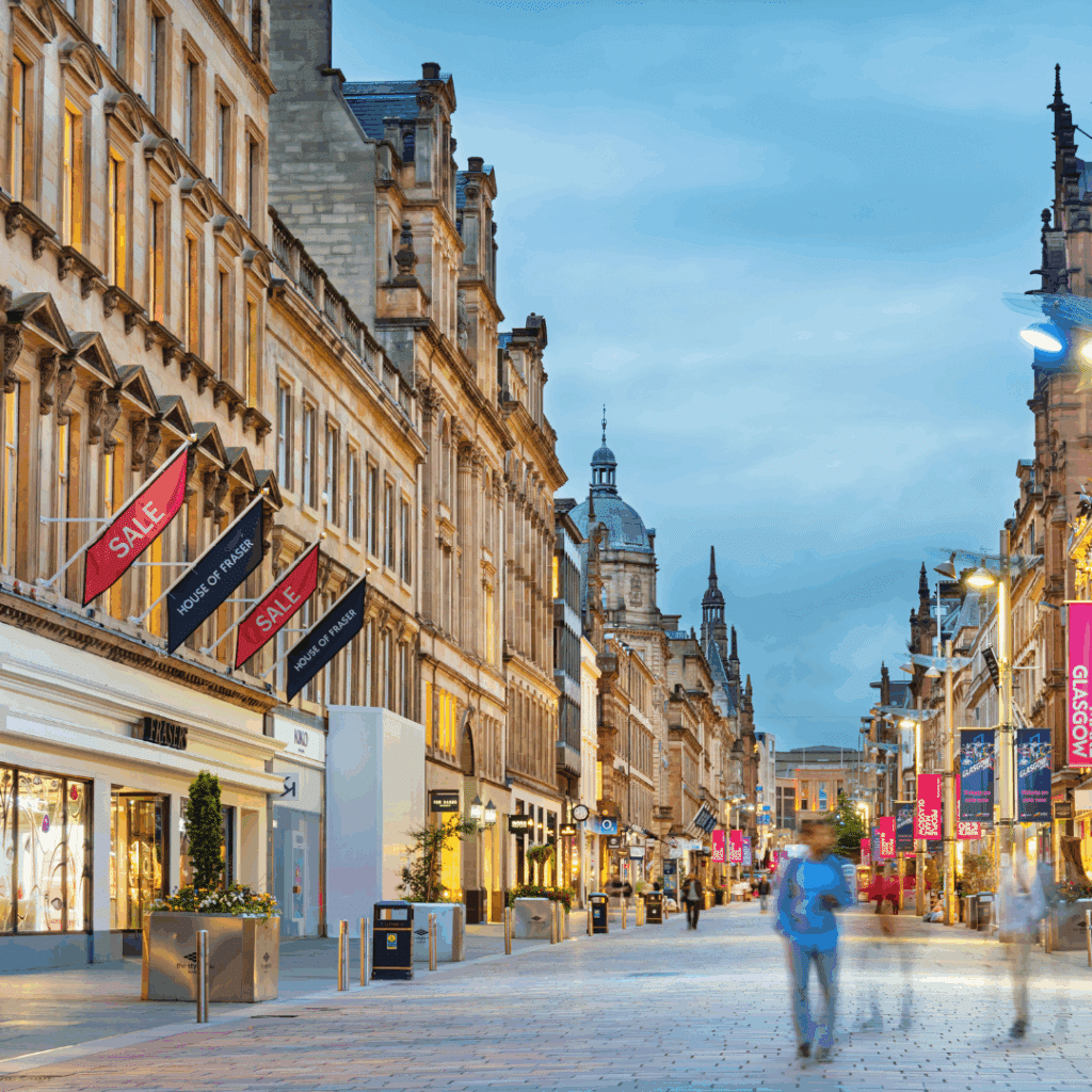 Pedestrian-friendly Buchanan Street with historic buildings and shopping signs in Glasgow.