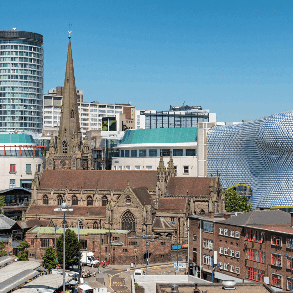 St. Martin's Church in Birmingham with the modern Bullring shopping centre and city skyscrapers in the background.