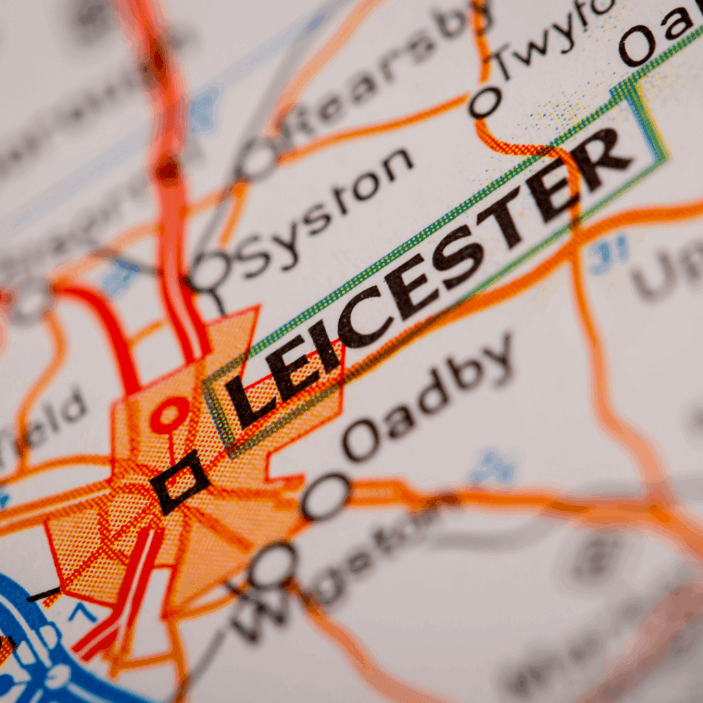 Close-up of Leicester on a printed map with surrounding towns and roads highlighted.