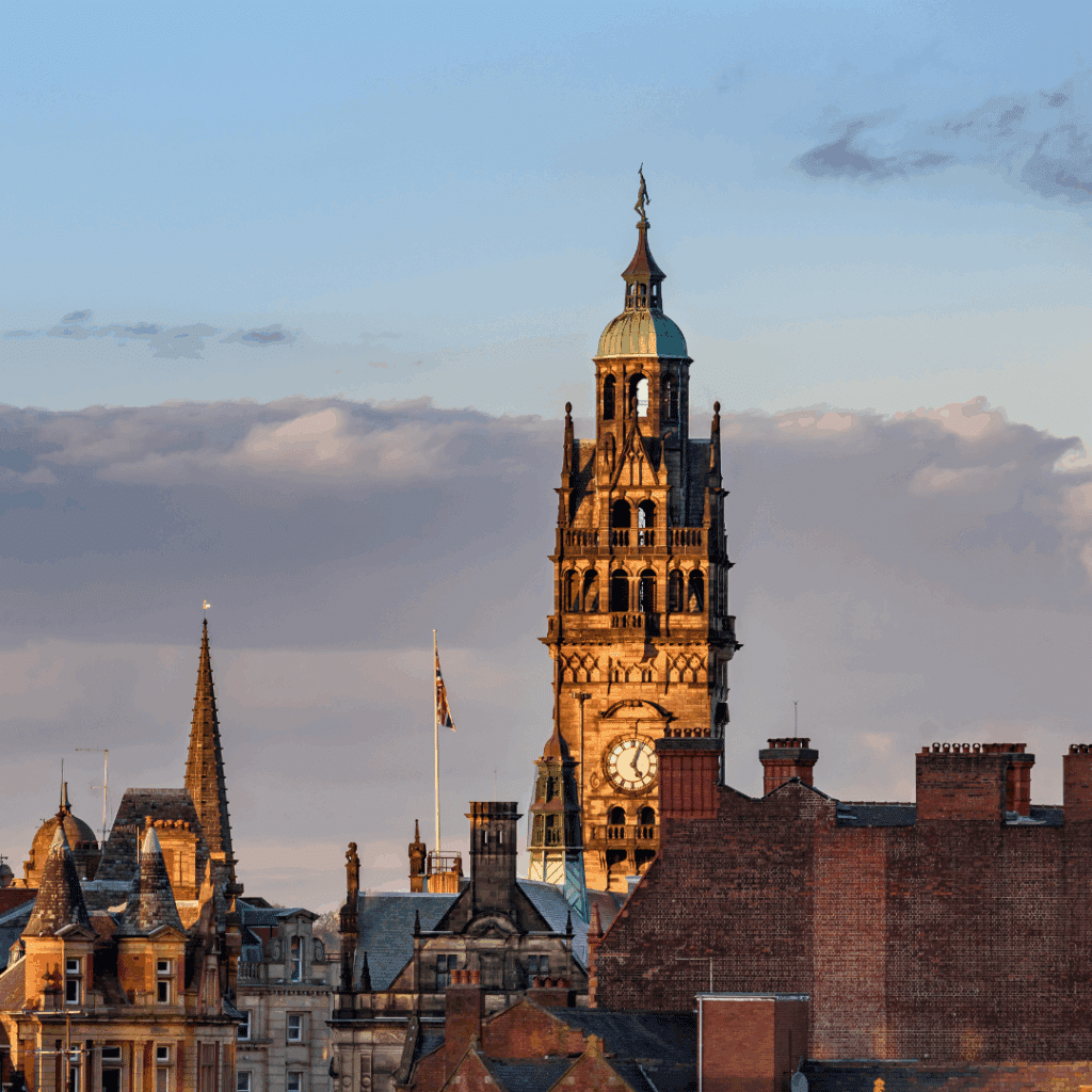 The clock tower of Sheffield Town Hall captured at sunset, standing tall among historic rooftops.