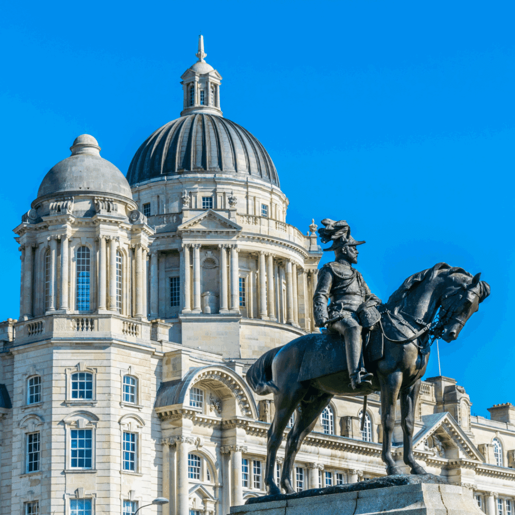 Classical dome and statue in front of the Port of Liverpool Building on a clear day in the city centre.