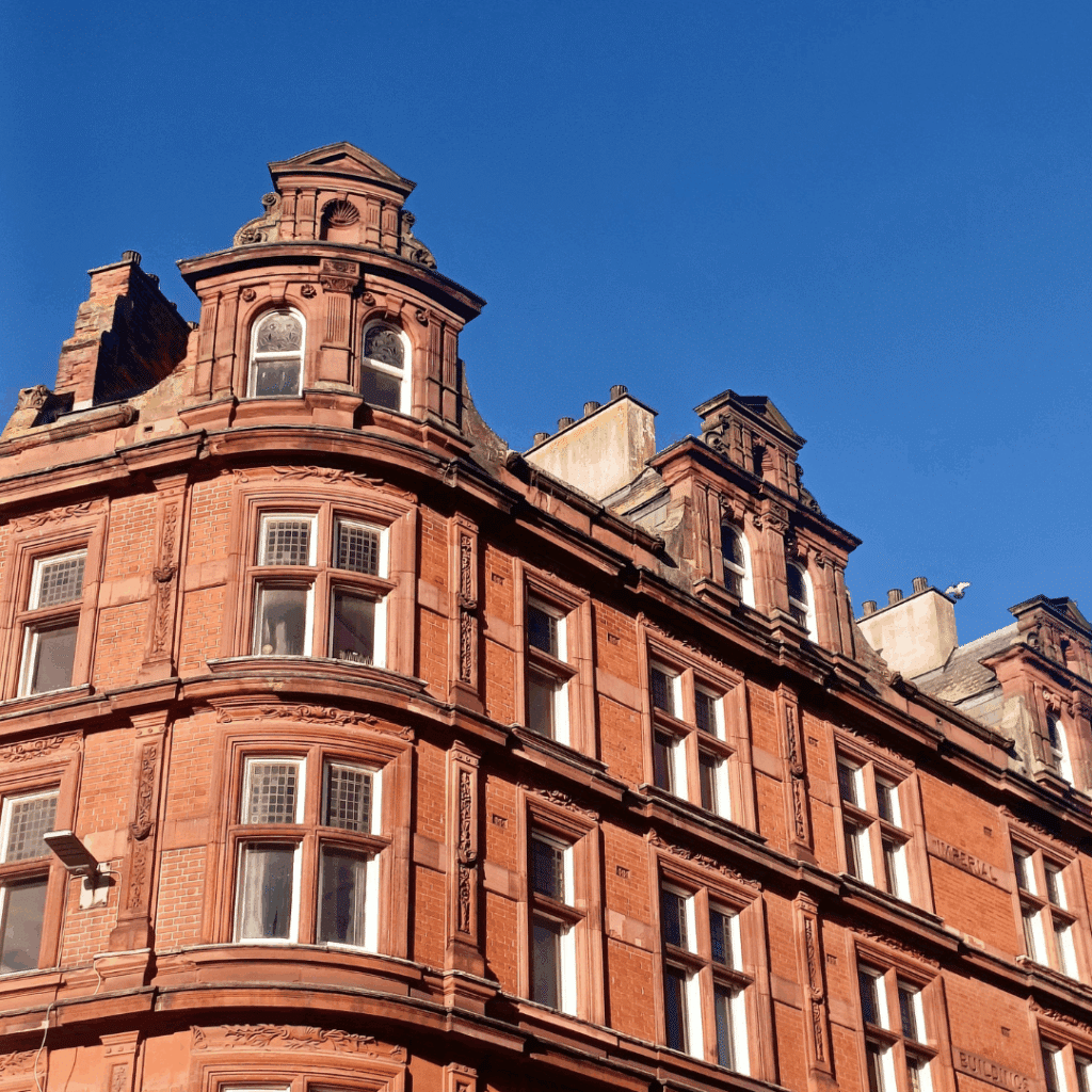 Ornate red-brick Victorian building in Leicester city centre against a clear blue sky.