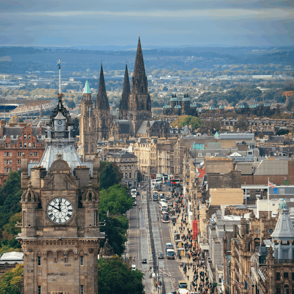 View down Princes Street, Edinburgh with the Balmoral Clock Tower and historic spires in the background.
