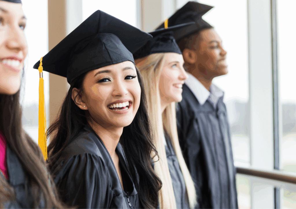 Smiling students wearing graduation caps and gowns, celebrating their academic achievements at a graduation ceremony.
