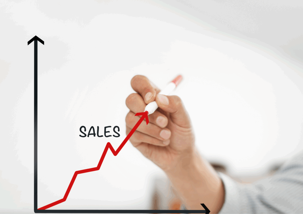 Hand drawing a red upward-trending line on a graph labeled “Sales,” symbolizing business growth and success.