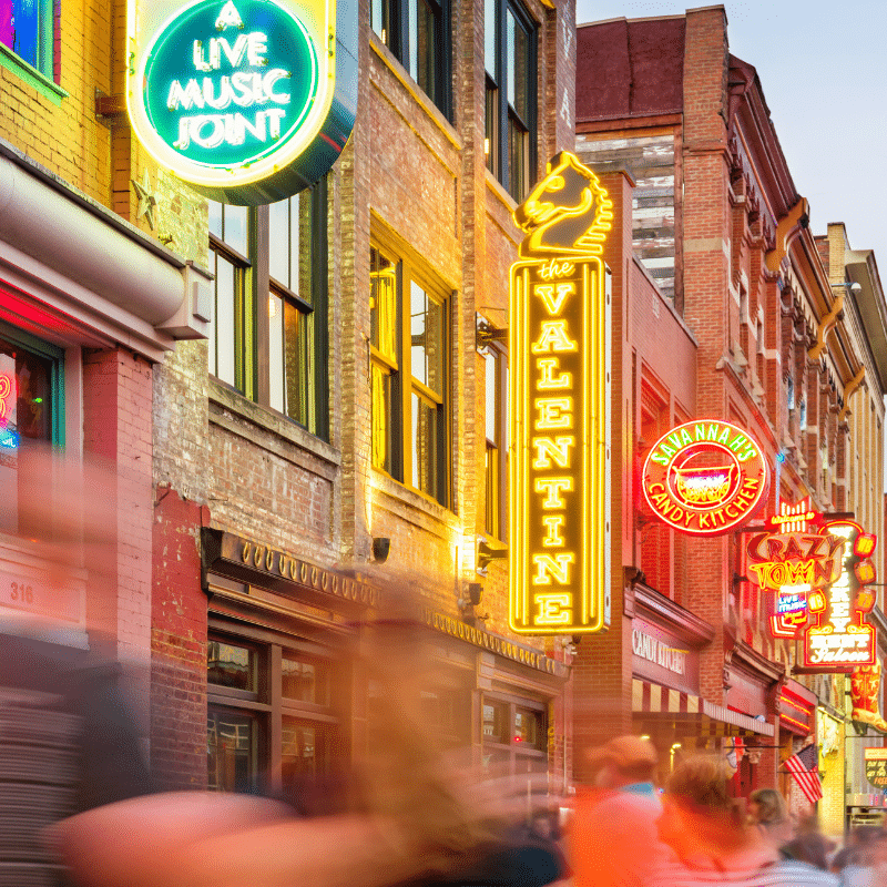 Bright neon signs and lively crowds along Broadway in downtown Nashville, showcasing the city’s famous live music venues and nightlife.