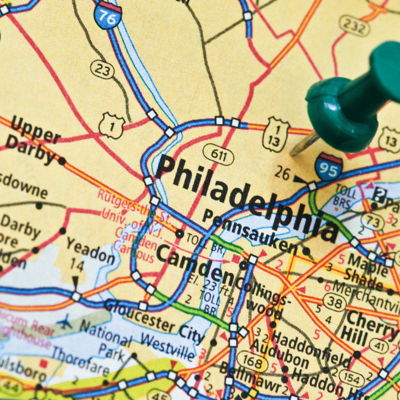 Close-up of a map showing Philadelphia, Pennsylvania with a green pushpin marking the city, highlighting its location and surrounding areas such as Camden and Upper Darby.