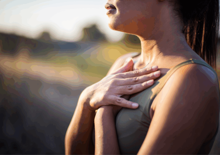 Woman outdoors with hands on her chest, practising mindfulness to calm nerves and focus on breathing.
