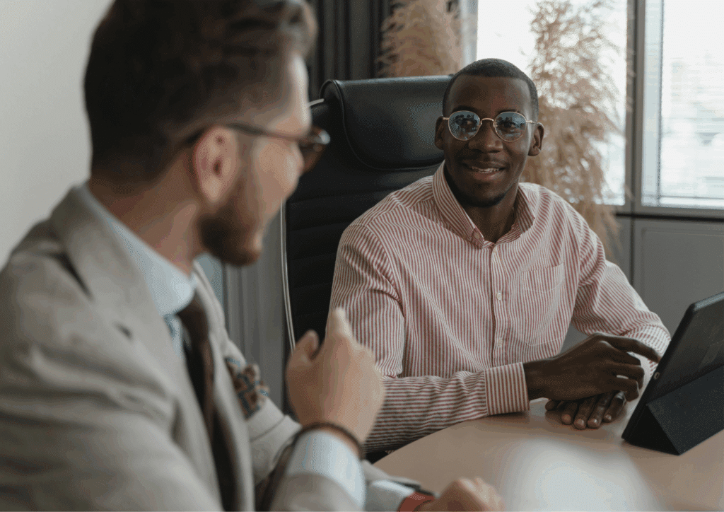 Two professionals smiling during a meeting, maintaining calm nerves while communicating confidently.