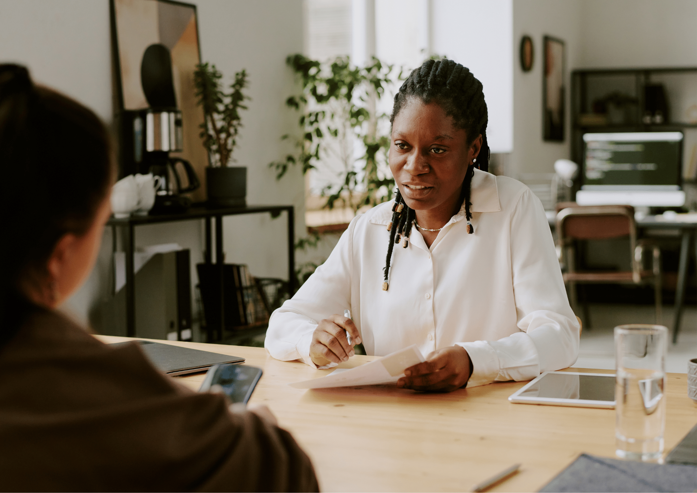 C-suite recruitment interview. Recruiter sitting across from a candidate at a desk, reviewing documents during a job interview.