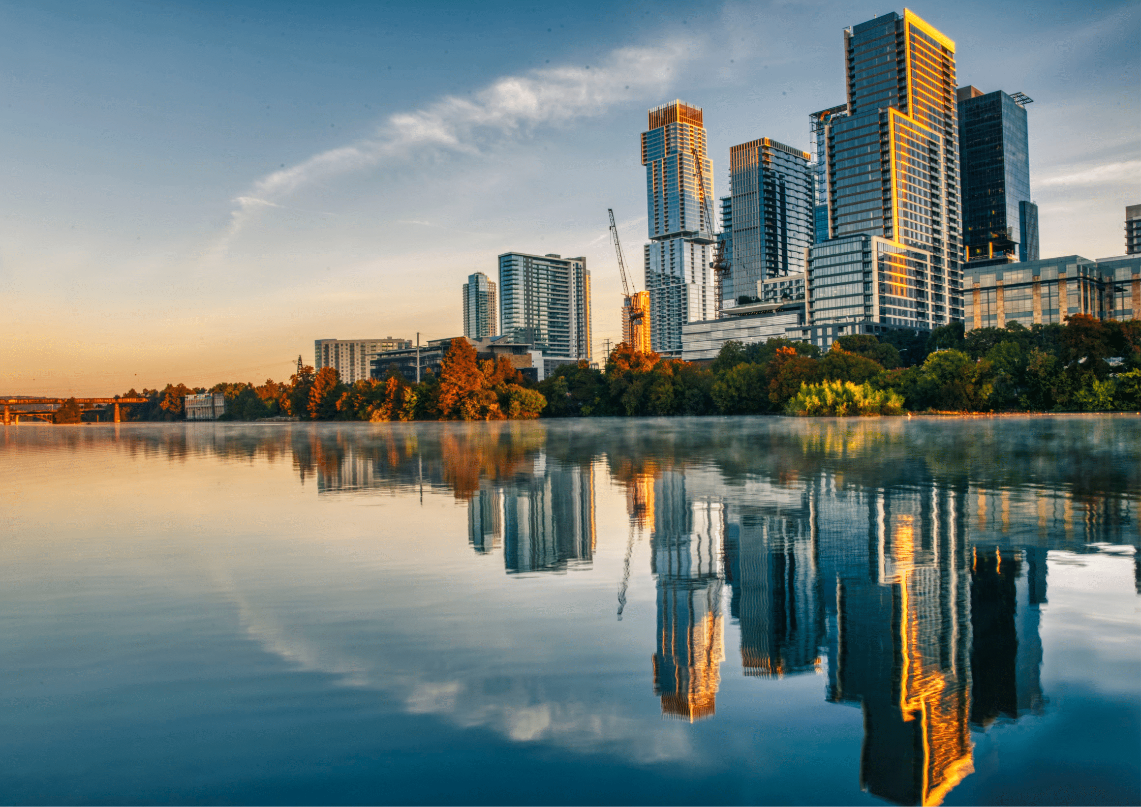 Modern high rise buildings in Austin, Texas reflected in calm water at sunrise.