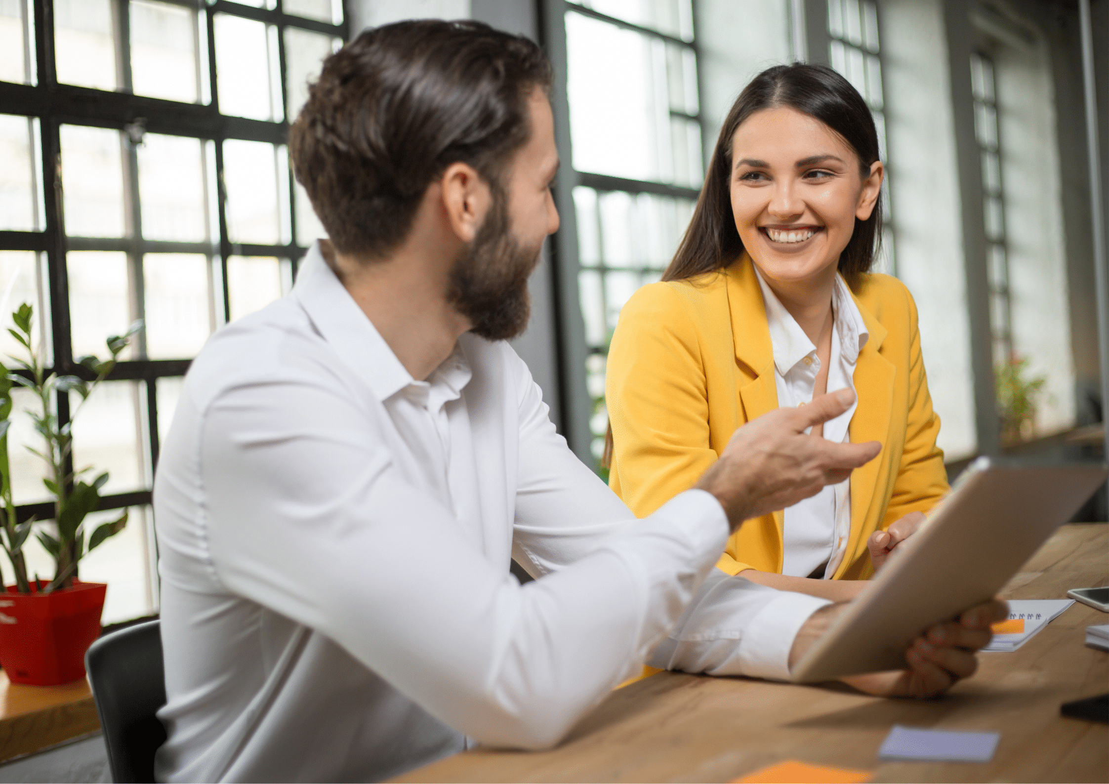 Two professionals discussing work on a tablet during a business meeting